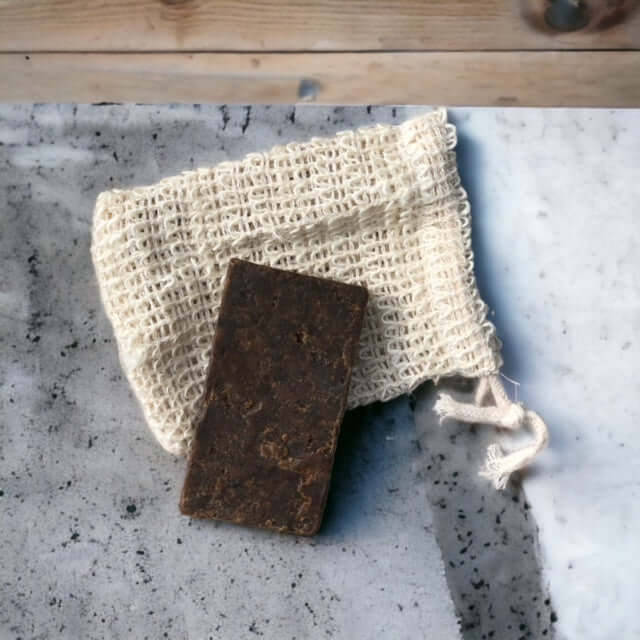Afrikaanse zwarte zeep op een sisalnetje op betonnen aanrechtblad 