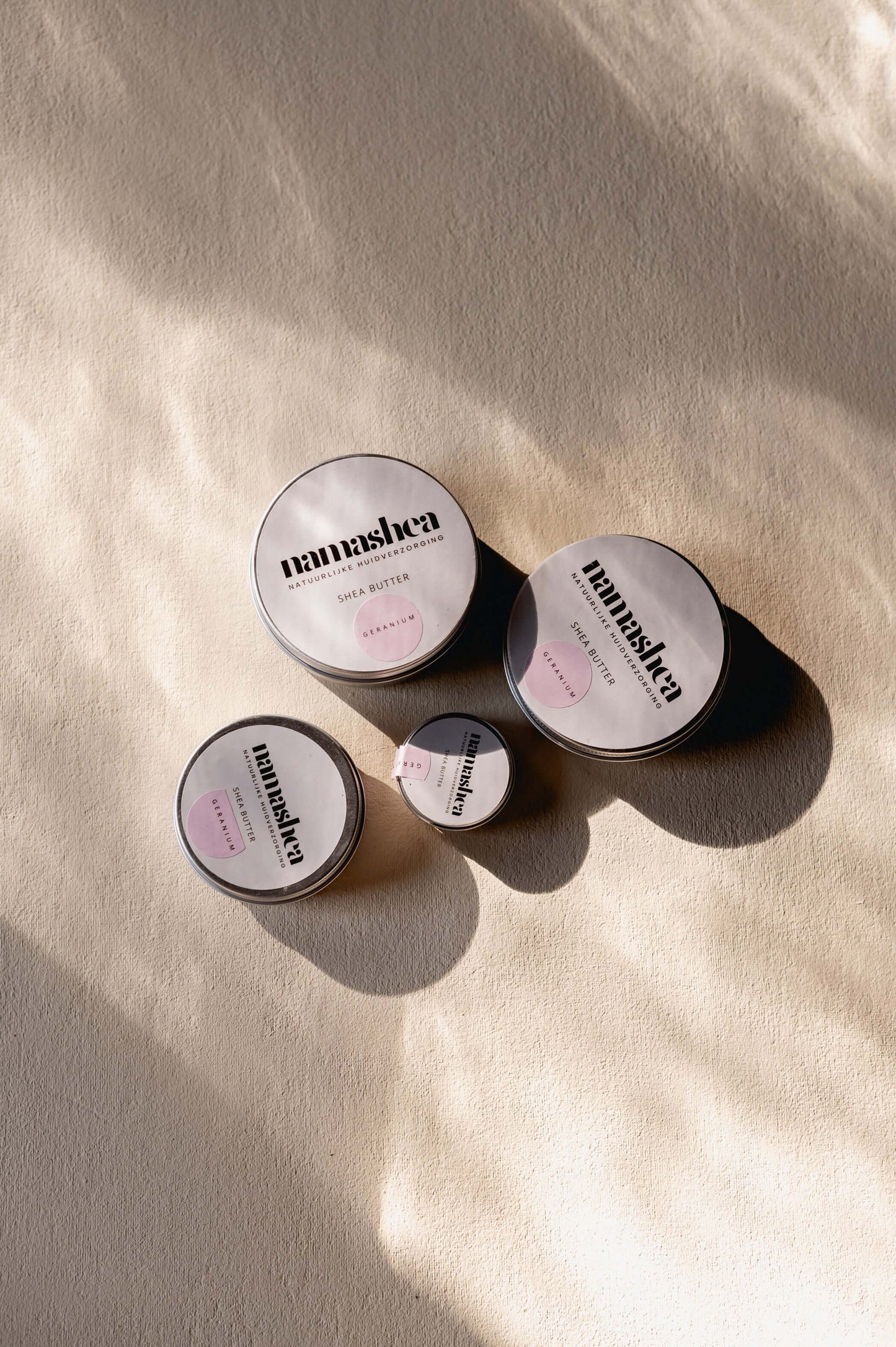 Assorted shea butter jars on a textured surface, showcasing natural skincare products.