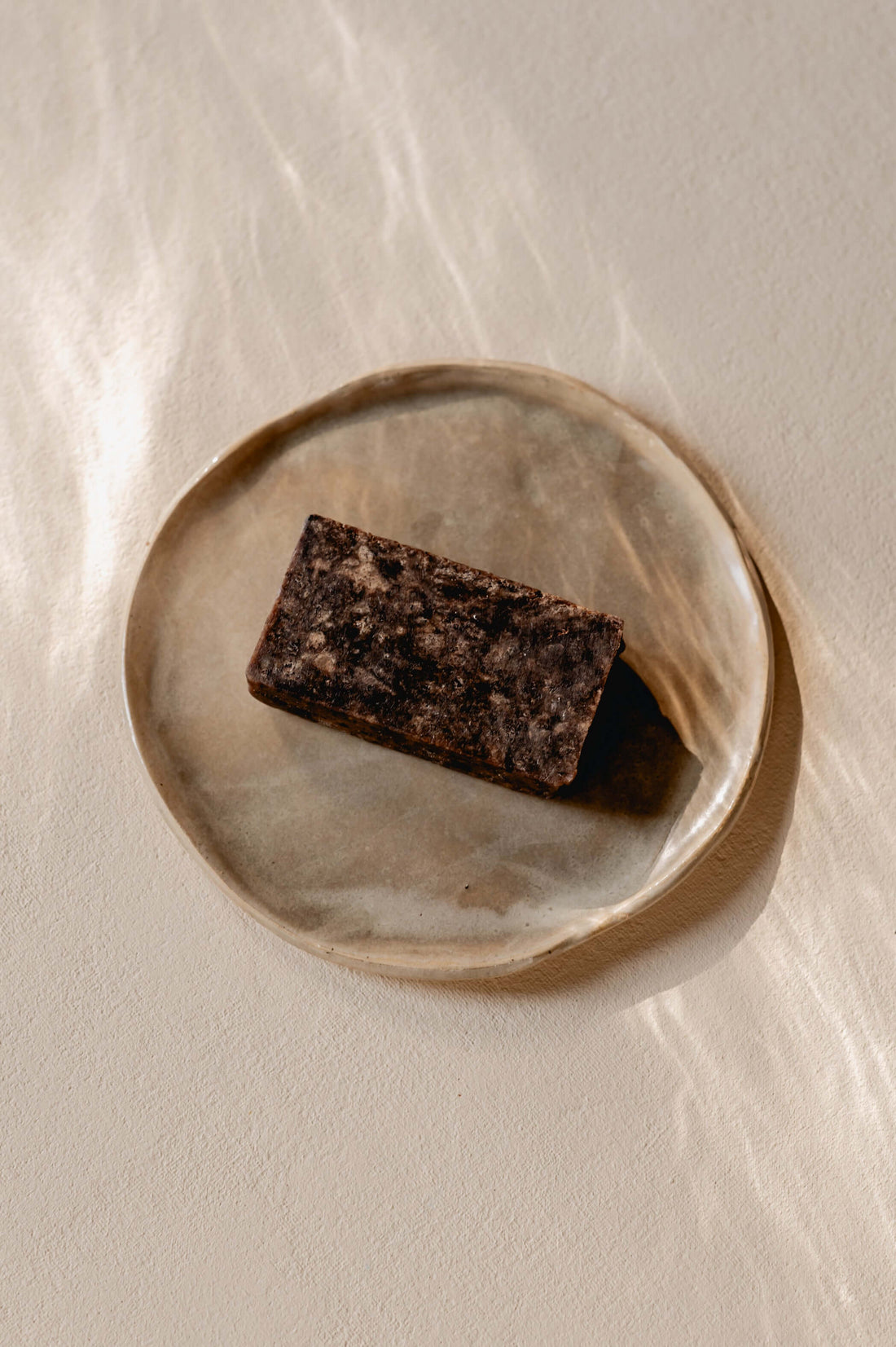 bovenaanzicht van zwarte zeep op mooi natuurlijk bord 