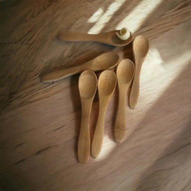 4 houten lepeltjes op houten tafel in prachtig zonlicht 