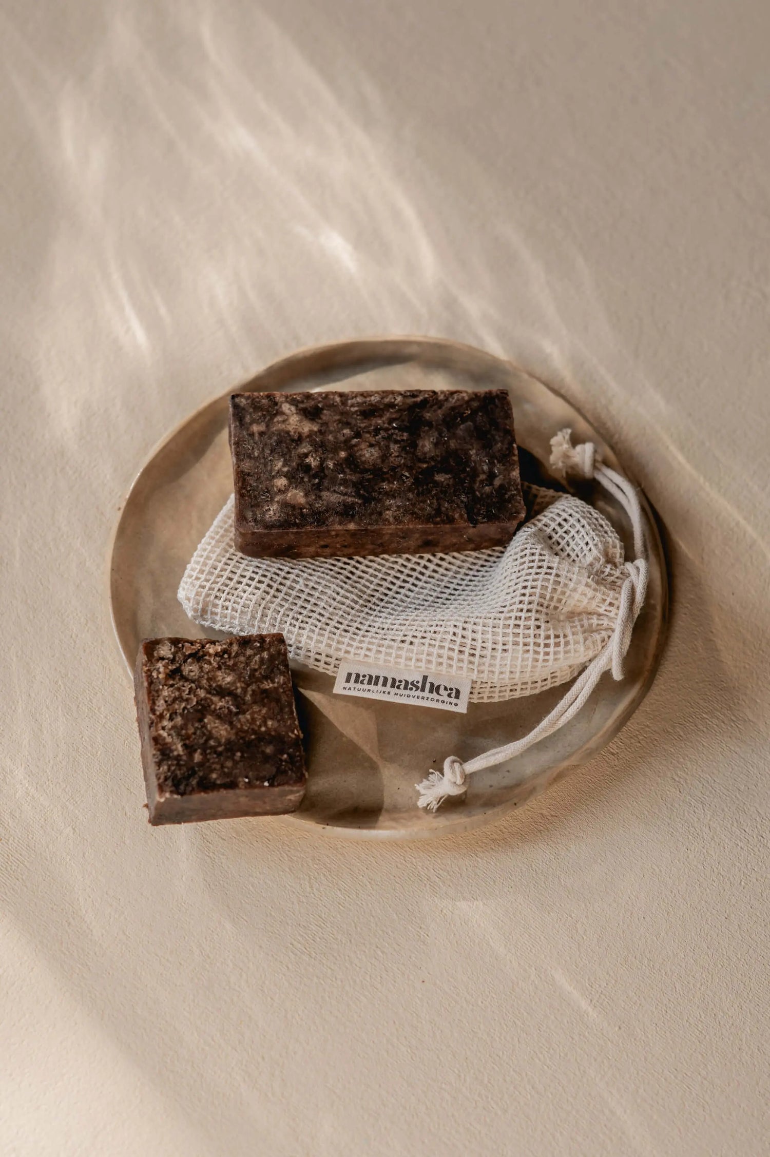 Afrikaanse zwarte zeep op een sisalnetje op betonnen aanrechtblad