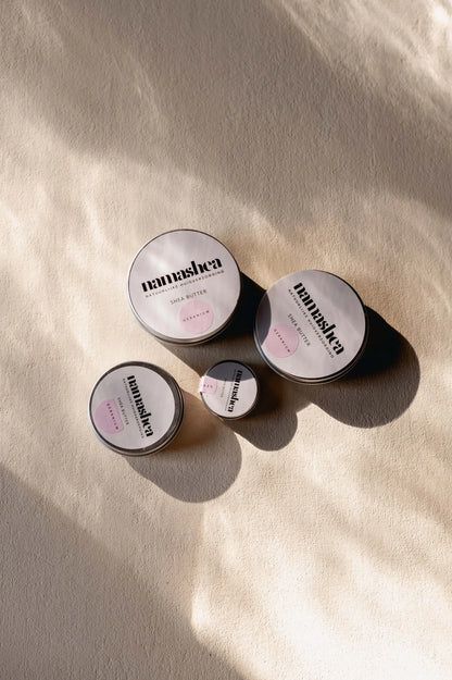 Assorted shea butter jars on a textured surface, showcasing natural skincare products.
