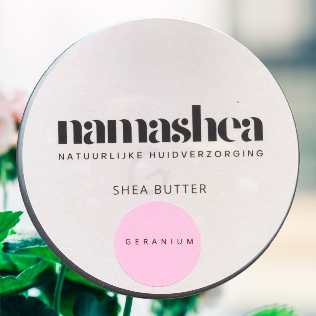 blik shea boter met geraniumolie van Namashea met frisse blaadjes op de achtergrond