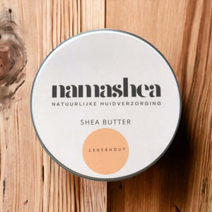 blik shea boter van Namashea met cederhoutolie op houten achtergrond 